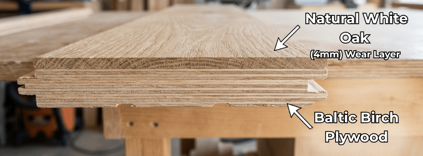 shown is a plank of engineered white oak. Complete with image descriptors pointing to the white oak wear layer (4mm) as well as the interlocking layers of marine grade Baltic Birch Plywood