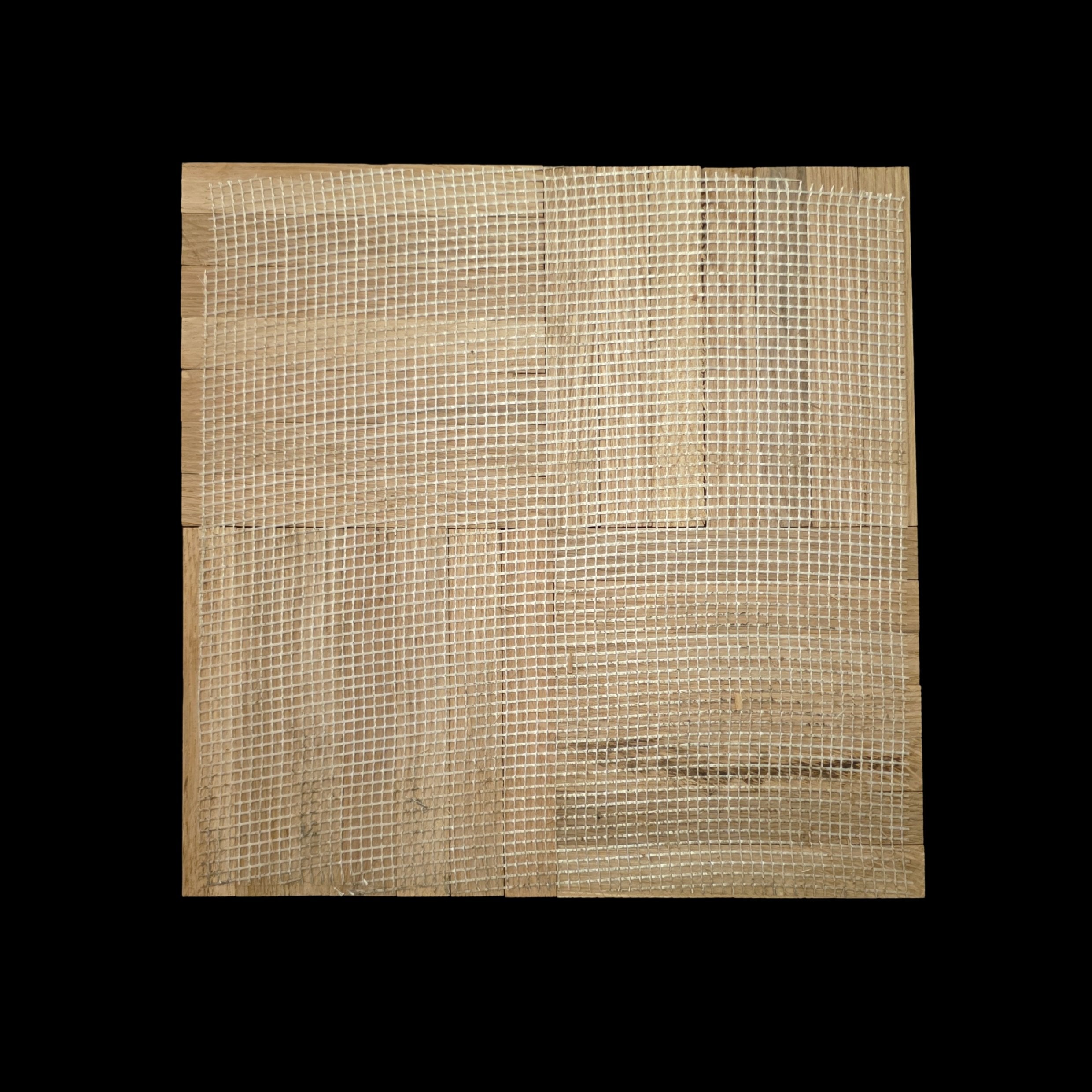 The back of a single 12"x12" - 7 finger - White Oak Parquet Tile. Shown with a webbed backing. The background is black.