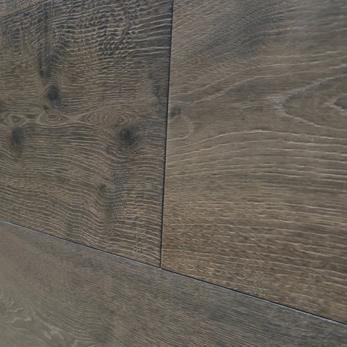 Close-up of dark brown wood flooring planks showing detailed grain patterns and seams between panels. Engineered European Oak Wide Plank Baronial Dusk Flooring is the product shown. 