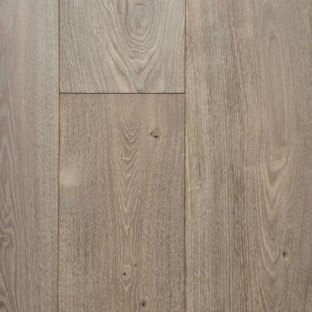 Light oak wood flooring planks with visible grain patterns and natural knots in a warm grayish-brown tone. The flooring in this image is Engineered European Oak Wide Plank Flooring Ember Valley.