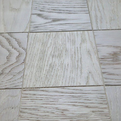 Light gray wood-look vinyl or laminate flooring tiles arranged in a grid pattern, showing various natural grain textures. Engineered European Oak Loire Mist Parquet flooring.