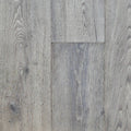 Gray wood-look plank flooring showing natural grain patterns and subtle knots on a clean surface. Image is of Engineered European Oak Luxe Timberline wide plank.