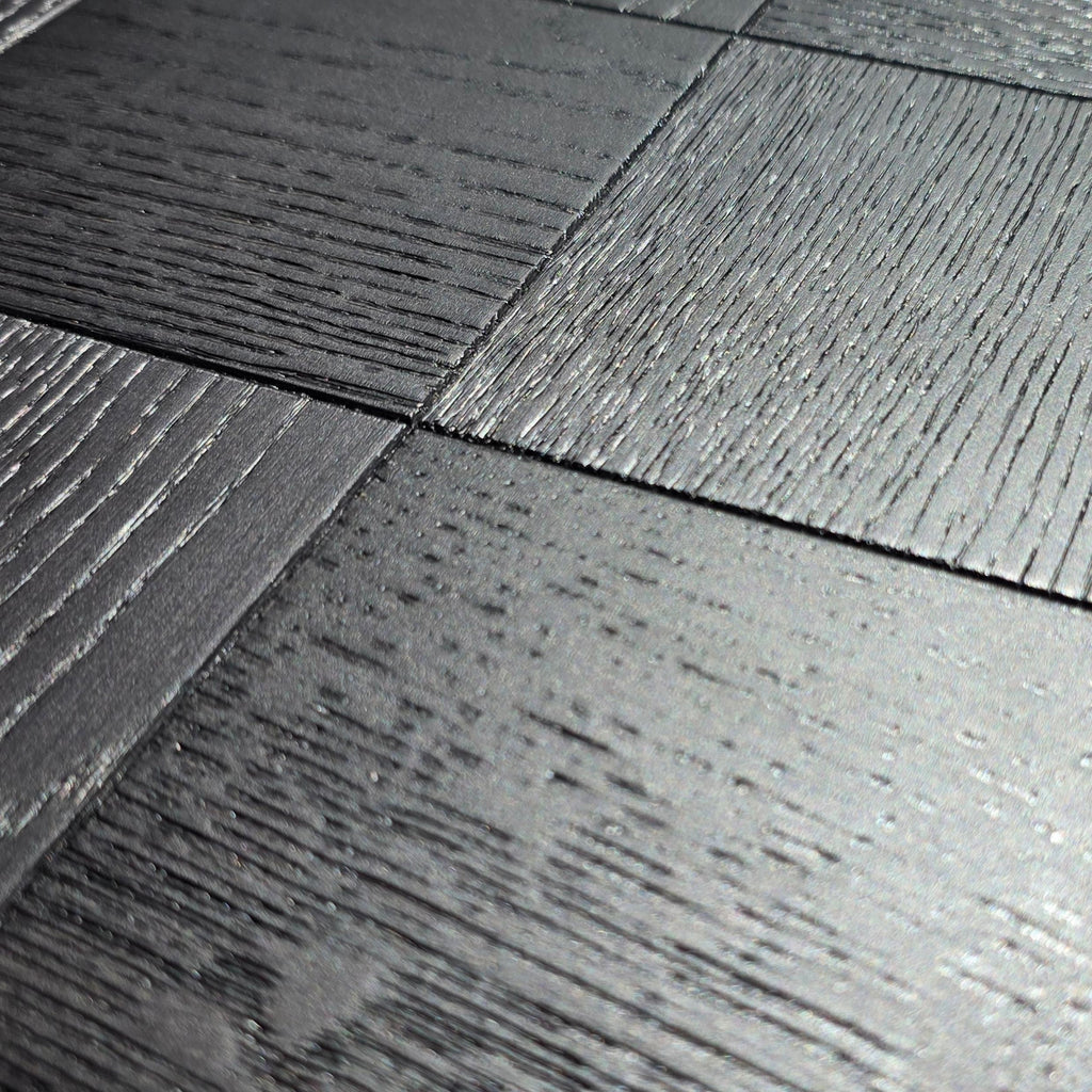Close-up of dark charcoal gray wood-look floor tiles with visible grain texture and subtle sheen. Engineered European Oak Ombre Royale - Parquet 
