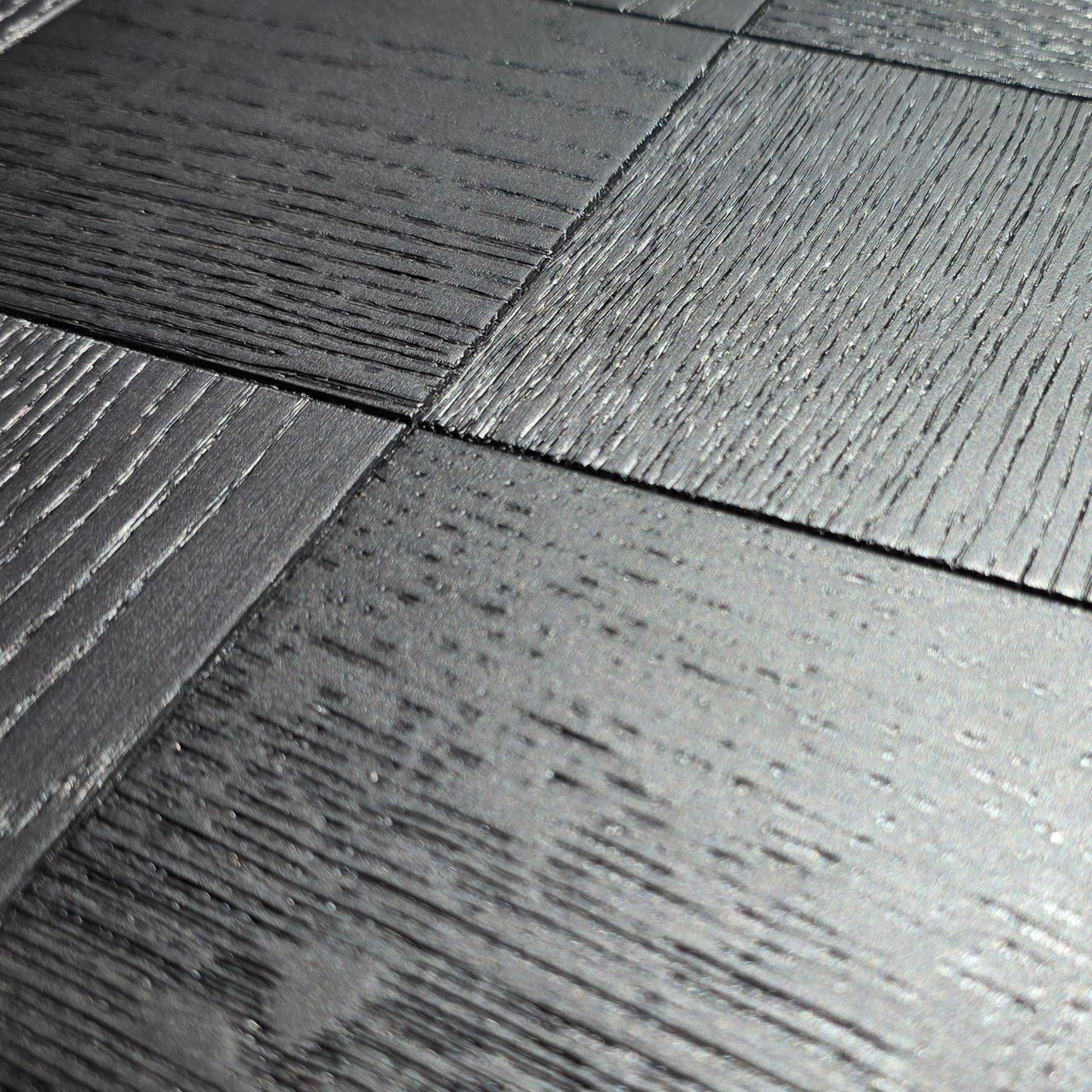 Close-up of dark charcoal gray wood-look floor tiles with visible grain texture and subtle sheen. Engineered European Oak Ombre Royale - Parquet 
