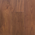 Medium brown Walnut wood flooring planks with prominent grain patterns and natural knots. Photo is of Velours Noyer - Wide Plank.