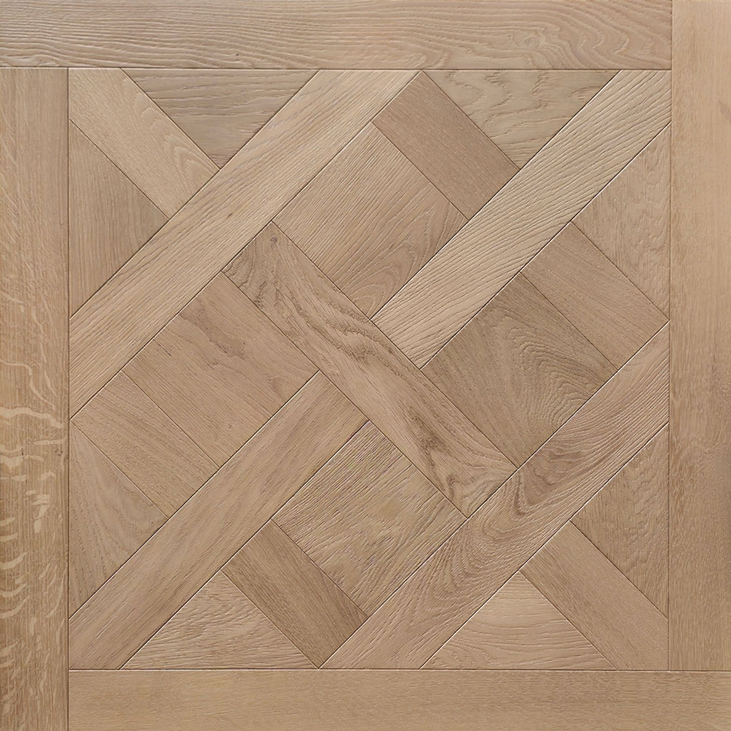 Light oak wood parquet flooring with a geometric herringbone and diamond pattern, featuring a matching solid wood border. Shown is  a single engineered European oak Gstaad Glow Parquet Tile.