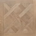 Light oak wood parquet flooring with a geometric herringbone and diamond pattern, featuring a matching solid wood border. Shown is  a single engineered European oak Gstaad Glow Parquet Tile.