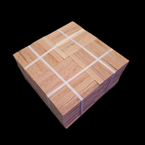 Unfinished Red Oak Parquet - 7 Fingers - 12" x 12" x 5/16" - Full Box Shown as 20 tiles stacked on top of each other. The tiles are being held together by 4 intersecting bands. Under the Bundle is a black cloth. 