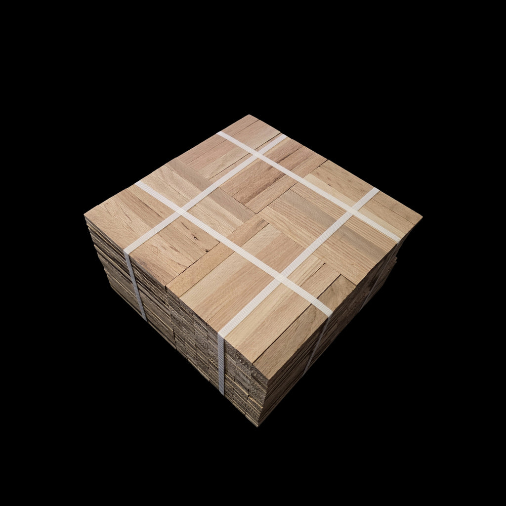 Unfinished Red Oak Parquet - 7 Fingers - 12" x 12" x 5/16" - Full Box Shown as 20 tiles stacked on top of each other. The tiles are being held together by 4 intersecting bands. Under the Bundle is a black cloth. 