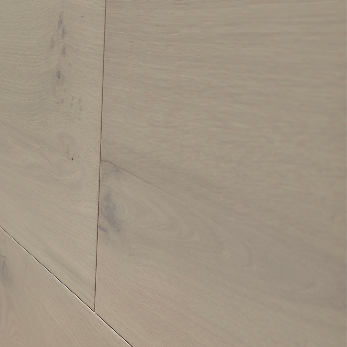Close-up of light oak wood flooring planks with visible grain and subtle bevels. Engineered European oak Whistler Ascent - Wide Plank is shown.