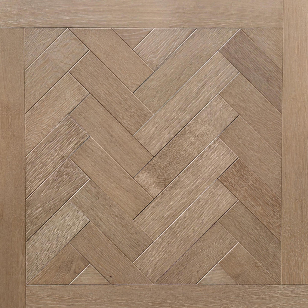 Light oak wood flooring shown in a herringbone parquet pattern with a matching wood trim border. engineered European oak hearthside Oak parquet is shown.