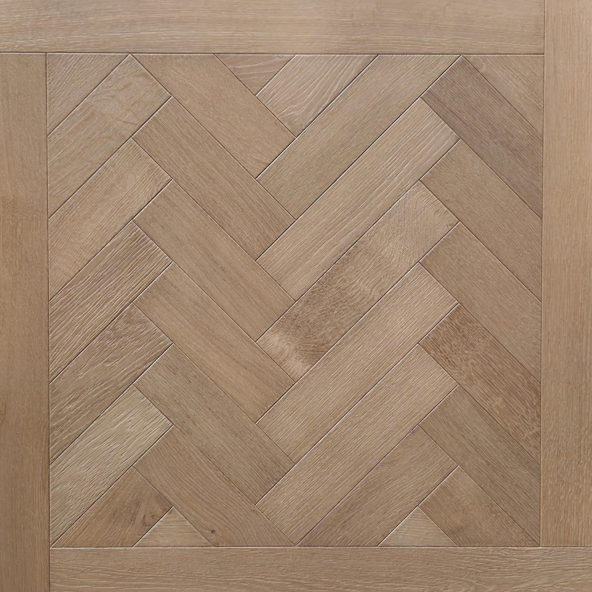 Light oak wood flooring shown in a herringbone parquet pattern with a matching wood trim border. engineered European oak hearthside Oak parquet is shown.